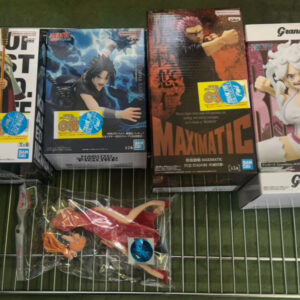 Row of anime action-figure boxes on a metal rack, with a loose packaged figure in front.