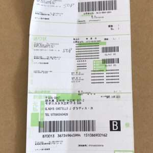 Shipping label on a brown cardboard surface with multiple barcodes, Japanese text, and a large '782' at the top.