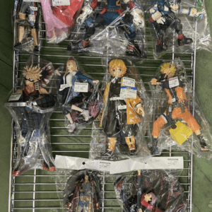 Assorted anime action figures in plastic bags on a metal display rack, arranged in rows on a green surface.