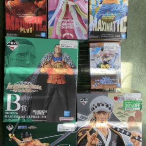 Boxed anime figures arranged on a rack: three top boxes feature One Piece characters and a pink kimono figure in the middle left-to-right.