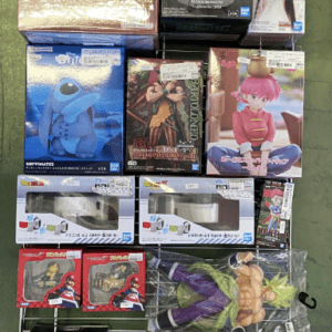 Assorted boxed anime action figures displayed on a metal rack. Various characters in colorful packaging take up multiple shelves.