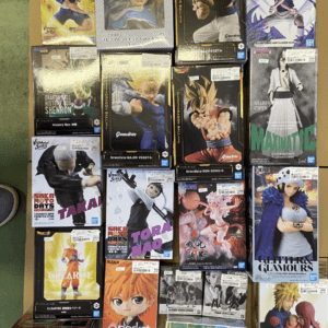 Collection of boxed anime figures arranged on a green floor, featuring characters from various series.