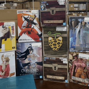 Stack of Japanese anime figure boxes on shelves, featuring Naruto, One Piece, and Overlord characters among other figures.