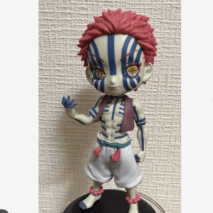 Figurine of a striped blue demon character with red spiky hair, white pants, and pink accessories waving. (informative toy image)