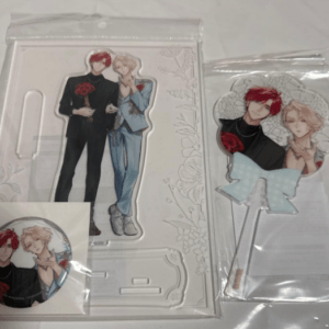 Two anime character standees with roses (red-haired in black, blond in blue) plus a round sticker and a bow accessory in clear packaging.