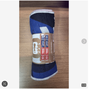 Rolled blue and black striped athletic sock with a FIFA official licensed product band around it on a wooden surface.