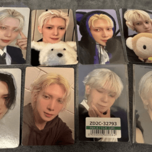 Eight glossy photo cards featuring a blond-haired man in various outfits, some with a stuffed bear, laid on a dark surface