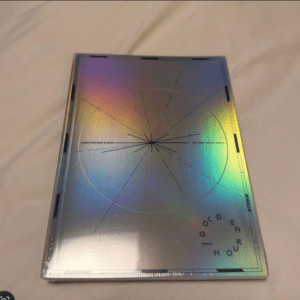 Holographic CD jewel case on a pale surface, with a circular geometric design and the words Golden Hour on the cover.