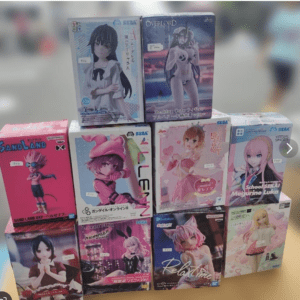 Stack of anime figurine boxes arranged on a stand, featuring colorful character boxes and logos (SEGA, Sand Land, etc.).
