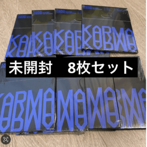 Eight unopened black boxes with bold blue geometric lettering arranged on a wooden floor; Japanese overlay reads 未開封 8枚セット (unopened, 8-piece set).