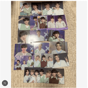 Collection of glossy BTS photo cards featuring Suga laid out on a beige carpet
