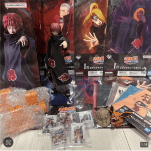 Display of Naruto merchandise: large character posters and action figures in black Akatsuki cloaks on a store shelf.