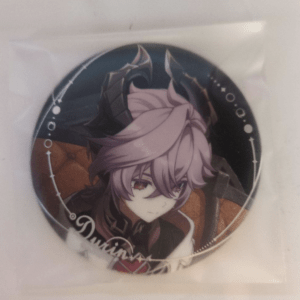 Round anime character pin showing a pink-haired character with red eyes, inside a plastic sleeve.