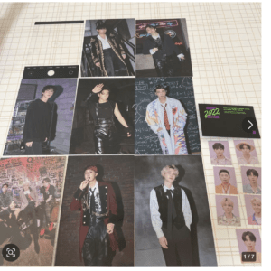 Collage of K-pop group members in various outfits, laid out on a grid-pattern surface, with a '2022 greetings' card and small photo sheets.