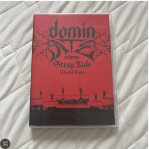 Red Stray Kids World Tour Japan DVD cover with a black band logo and silhouettes of performers on a red stage背景.