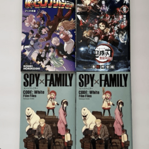 Four manga volumes on a white surface: My Hero Academia, Demon Slayer, and two Spy x Family issues with colorful illustrated covers and bold titles on each spine/cover.