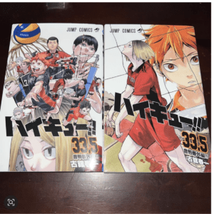 Two Haikyu!! manga volumes on a table, featuring colorful volleyball players in action on the covers.