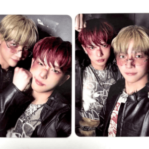 Two young men in leather jackets pose for a split-screen selfie, one with blond hair and sunglasses and the other with red hair.