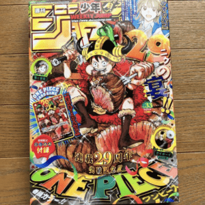 Colorful Japanese manga magazine cover featuring Luffy in a red cape fighting a beast, with large 'ONE PIECE' at the bottom and 'WEEKLY JUMP' logo top center.