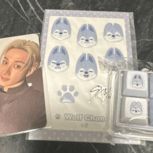 Photo card of a person with blond hair, next to a Wolf Chan sticker sheet and a package of lavender wolf-faced erasers.  Articulos Japan (Post Box Japan)