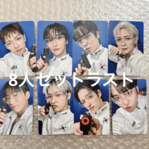 Eight young men in white jackets wearing safety goggles pose with black toy guns against a blue background—text overlay in white across the collage.