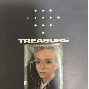 Album cover for Treasure featuring a portrait of a person with blond hair and round glasses inside a clear case on a dark background with star-like symbols above the title.