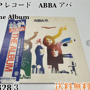 Album cover for ABBA's The Album with colorful abstract figures and a blue vertical strip reading ABBA THE ALBUM