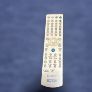 Silver Sony PSX remote control with numerous buttons, shown against a blue background.