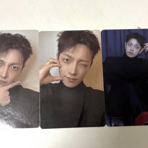 Three photocard images of a young man with short dark hair in a black turtleneck, posing in different ways: left card with hand on chin, middle card winking and forming a circle with fingers near the eye, right card seated in a dark setting with a blue backdrop.