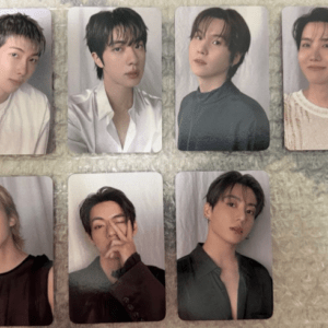 Eight glossy portrait photo cards of young men laid out on a light textured surface in two rows of four each.
