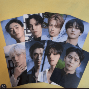 Nine glossy portrait cards of a K-pop boy band arranged on a yellow background, showing close-up headshots.