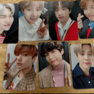 Seven photo cards featuring smiling young men posing for selfies on a wooden table.