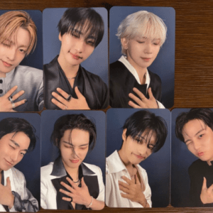 Eight glossy portrait photo cards featuring young men posing with a hand on the chest, blue backdrops, arranged in two rows of four on a wooden table.