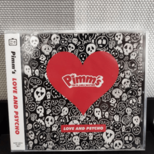 CD album cover with a large red heart logo that says 'Pimm's' on a black skull-patterned background; title 'Love and Psycho' shown on a red label below the heart.  Articulos Japan (Post Box Japan)