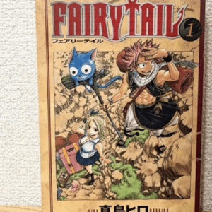 Fairy Tail volume 1 manga cover featuring Natsu, Lucy, and Happy on rocky groundy terrain.