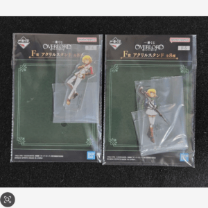 Two boxed Overlord acrylic stand figures in plastic packaging, laid side by side on a dark surface.