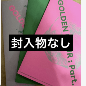 Bright pink, green, and gray booklets stacked together with a black banner across the center reading '封入物なし' (no inserts).