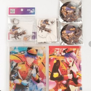 Collection of anime merch: two large illustrated cards featuring a purple-haired soldier in orange uniform, plus keychains, circular badges, and small character stickers.