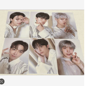Six portrait photo cards featuring young men in light outfits arranged in two rows of three on a beige background (photocard collection).