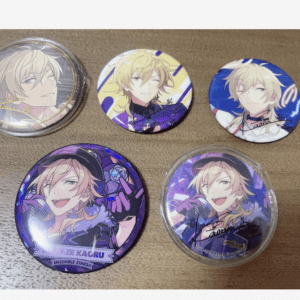 Six round anime pins laid on a wooden surface, each featuring blond male characters in colorful outfits.