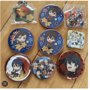 Collection of round anime buttons featuring chibi characters on starry blue backgrounds, laid out on a wooden surface.