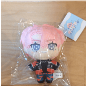 Plush toy of a pink-haired anime character in a black and red outfit, sealed in clear plastic with a blue tag.